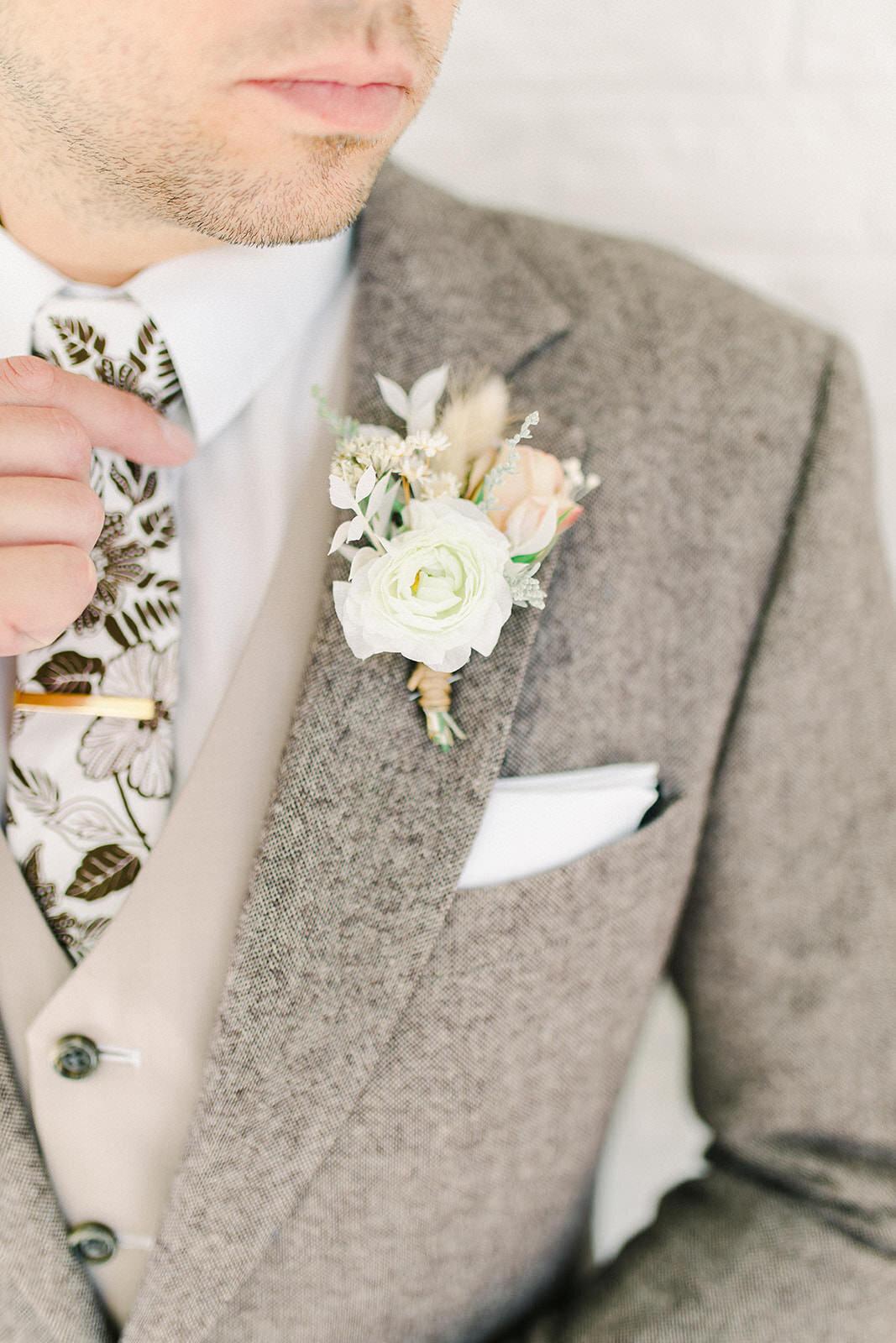 Fine art groom with brown suit and boutonniere