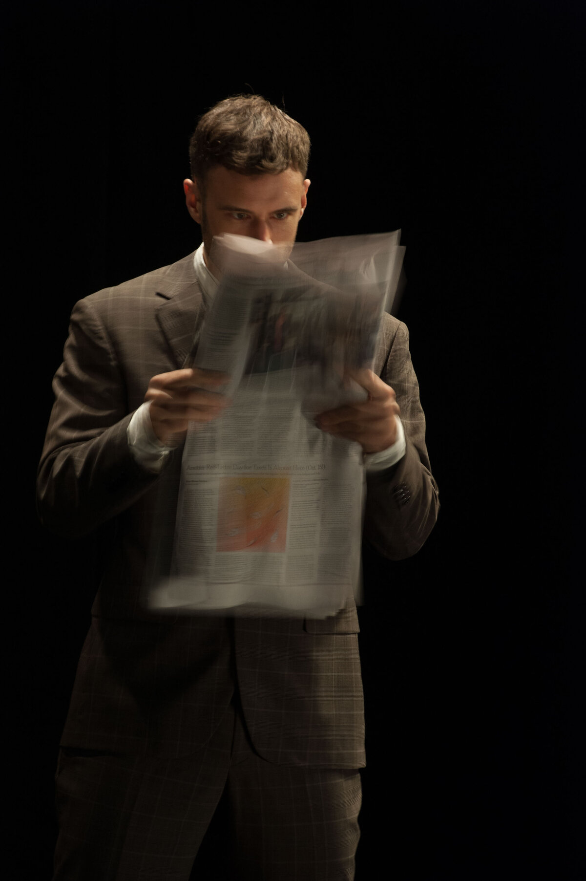 Man in suit reading newspaper