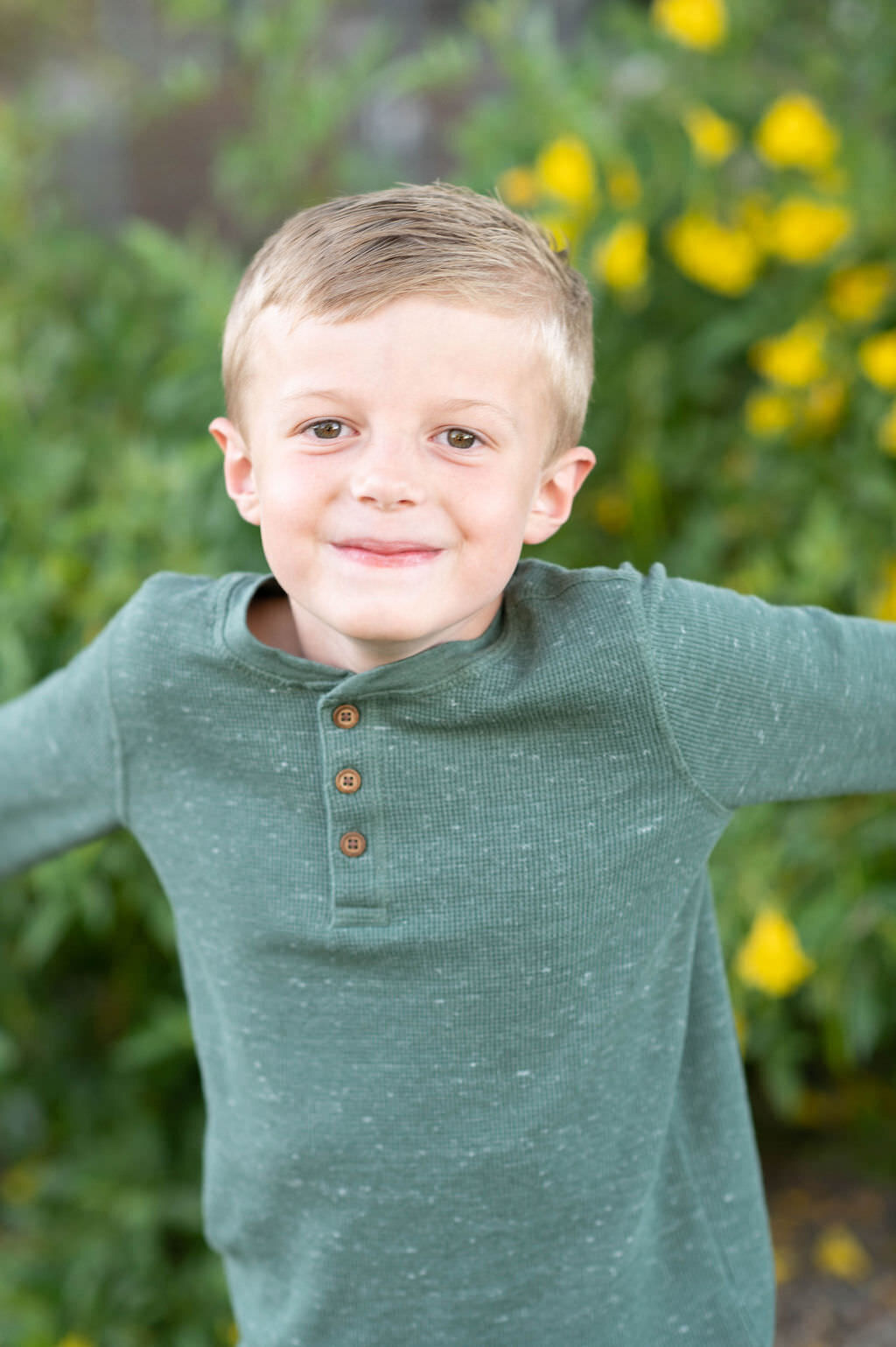 A boy with his arms out smiling.