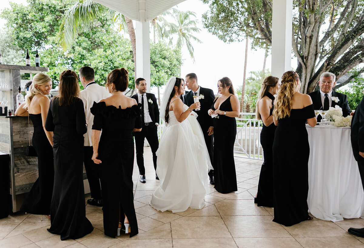 Guests mingling during the cocktail hour at Ashley and Cameron's micro wedding at Ocean Reef in Key Largo, captured by Claudia Amalia Photography.