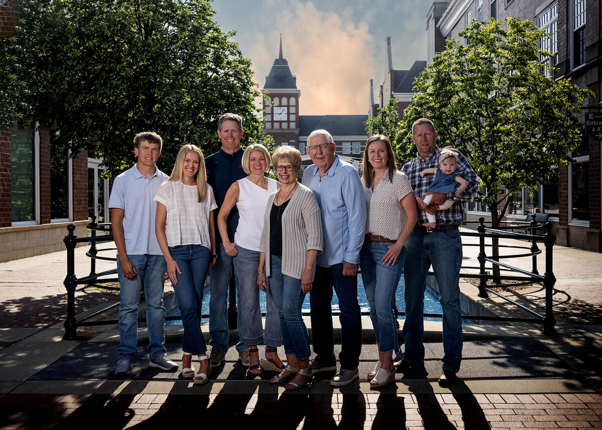 A Pella Family Photographer takes photos of a family who pose on the city square