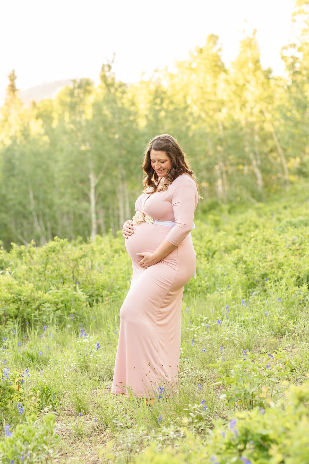 a pregnant woman standing in a filed