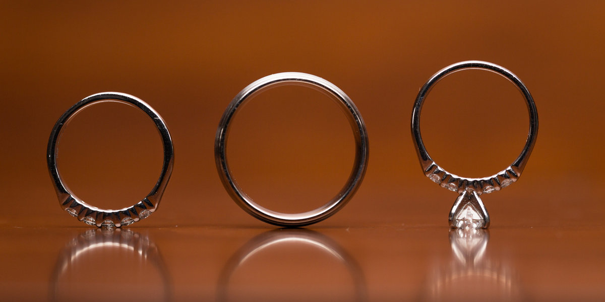 Wedding rings standing on wooden table.