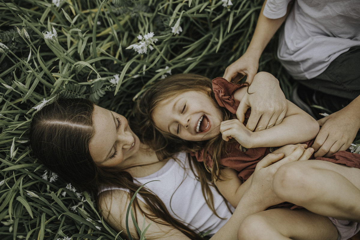 Kids laughing and playing on ground in field tickling for Melbourne Family Photography Session  with Sapphire and Stone Photography
