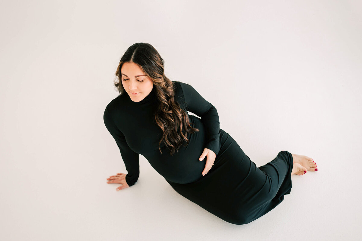 Springfield Mo materniy photographer captures pregnant mom holding baby bump sitting on floor