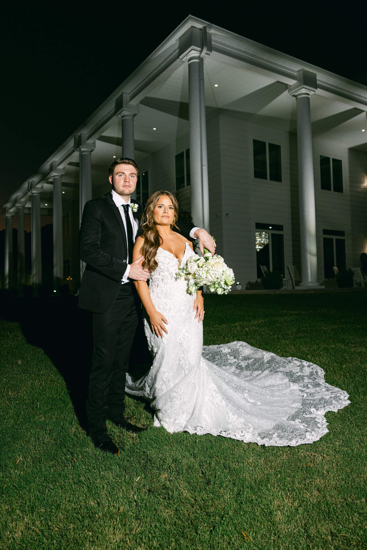 A wedding photo of the bride and groom in front of their wedding venue legacy acres