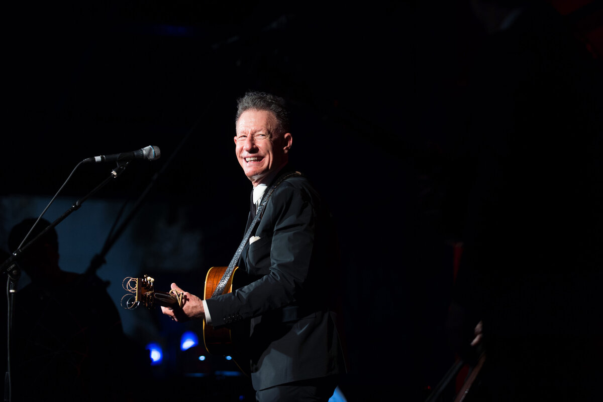 Lyle Lovett performs in San Antonio while smiling with guitar