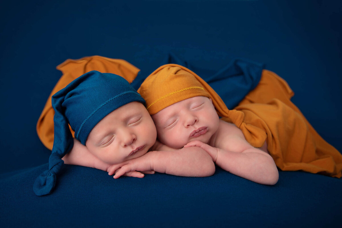 twin boys wearing blue and orange for their twin Burlington Newborn Photography session.