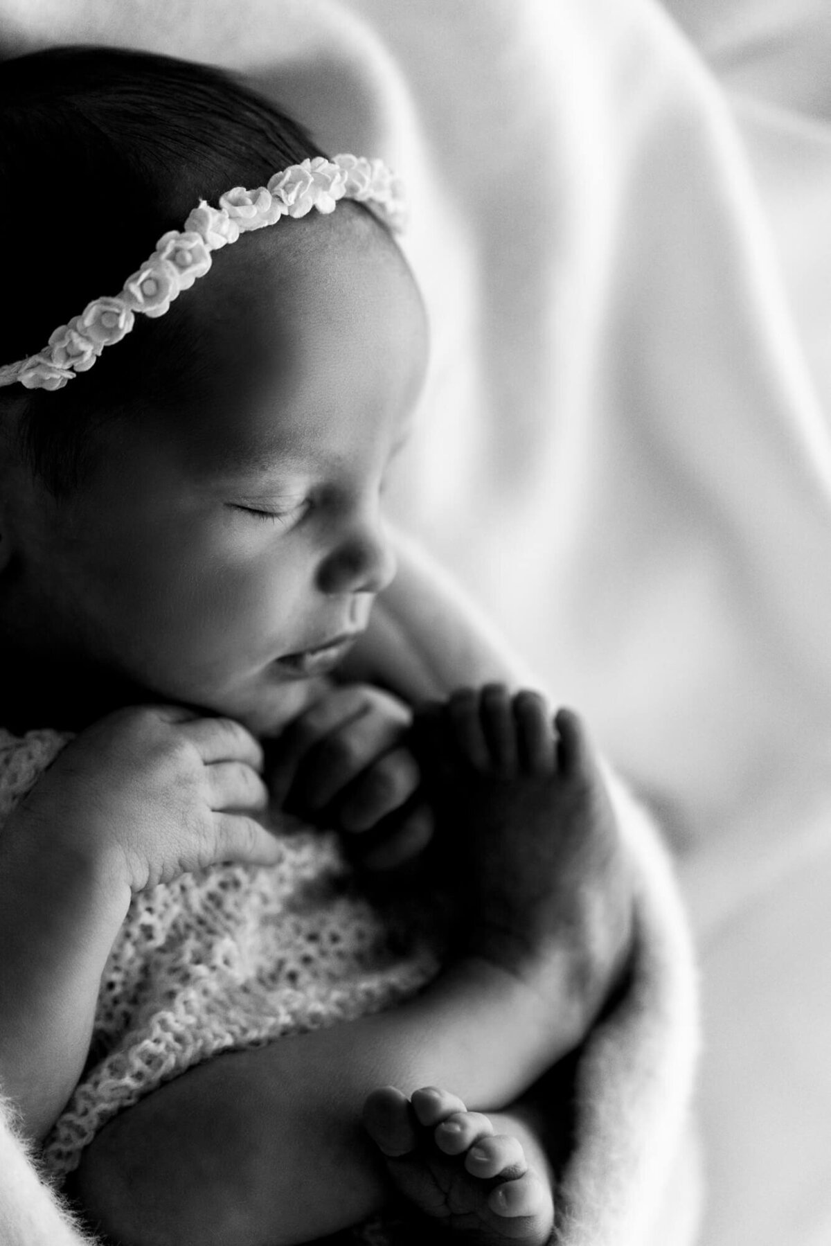 Black and white macro photo of a one week old baby girl.