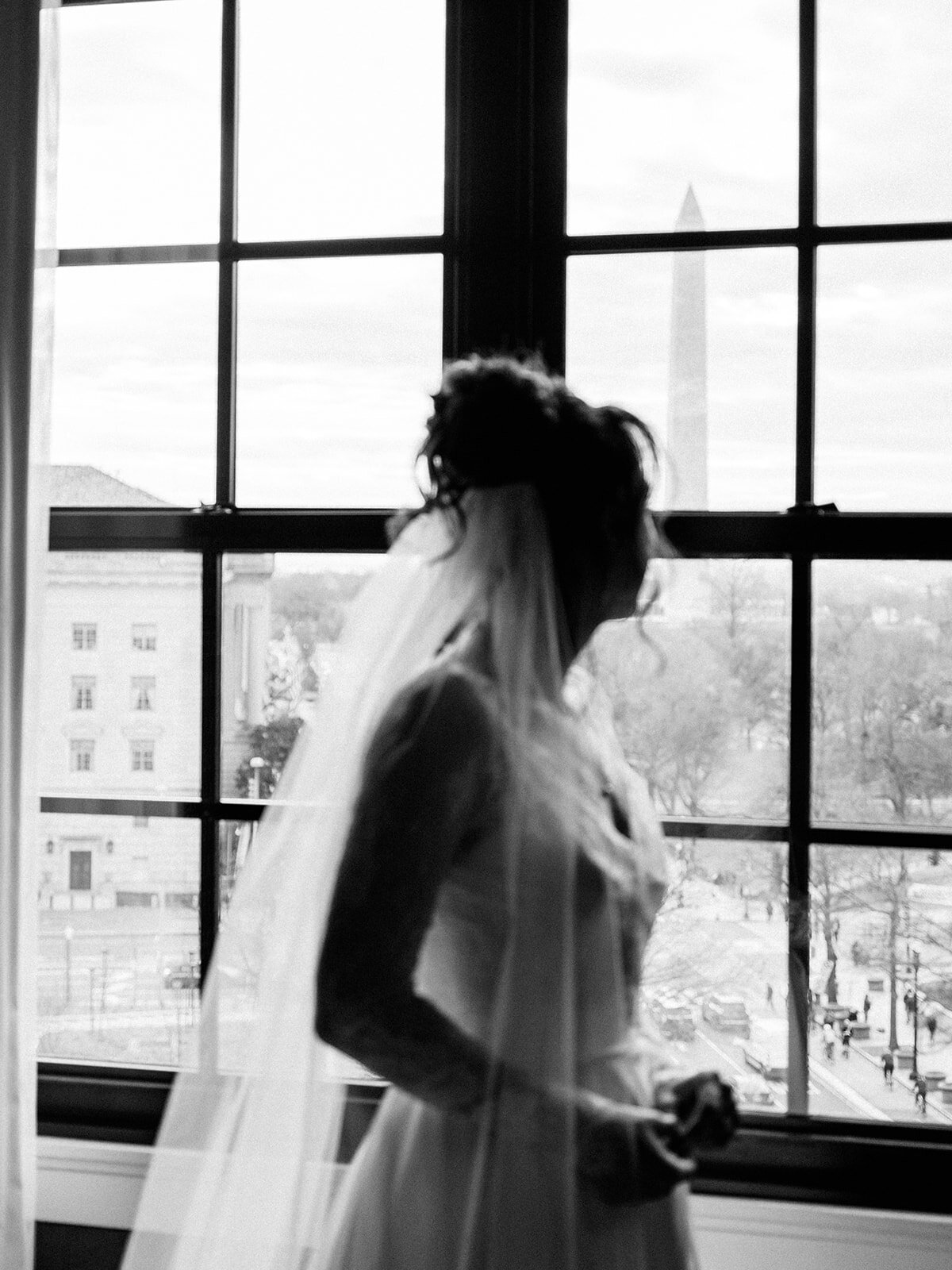 Bride looking out the window at Hotel Washington 