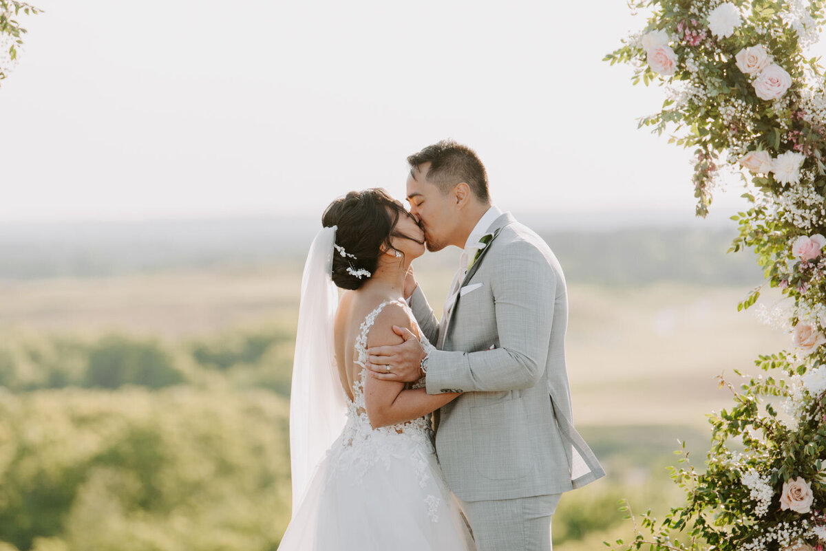 Bride and groom kissing in an outside scenery