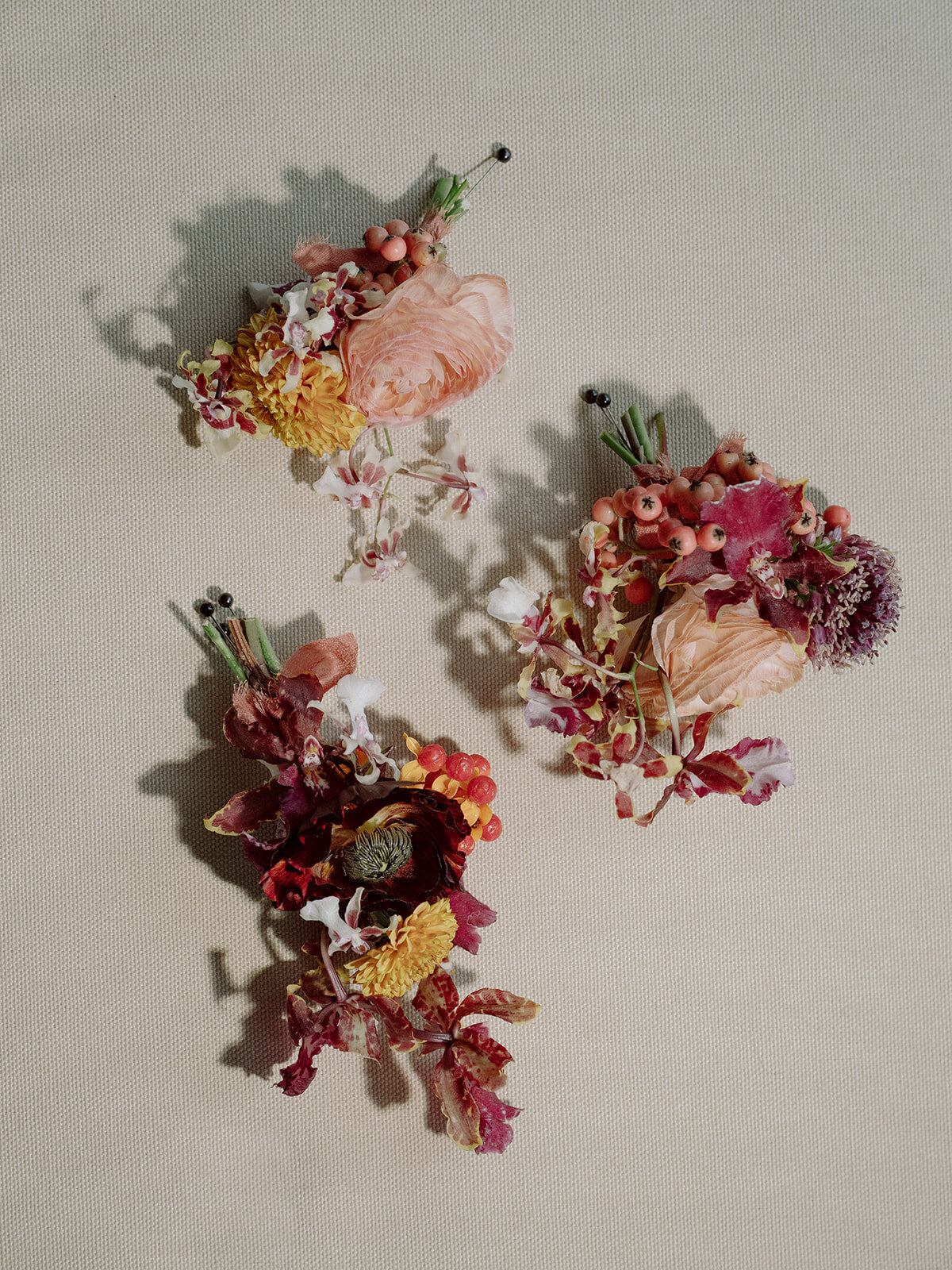 Artistic and textural boutonnieres for autumnal wedding in Tennessee hills. Unique and colorful groomsmen boutonnieres. Boutonnieres in colors of copper, gold, lavender, and ruby featuring orchids, ranunculus, and wildflower textures. Private home wedding ceremony and reception. Design by Rosemary & Finch Floral Design in Nashville, TN.