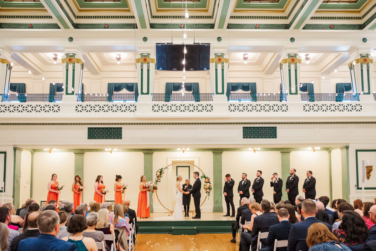 wedding ceremony on the stage at soldiers and sailors memorial hall with guests watching