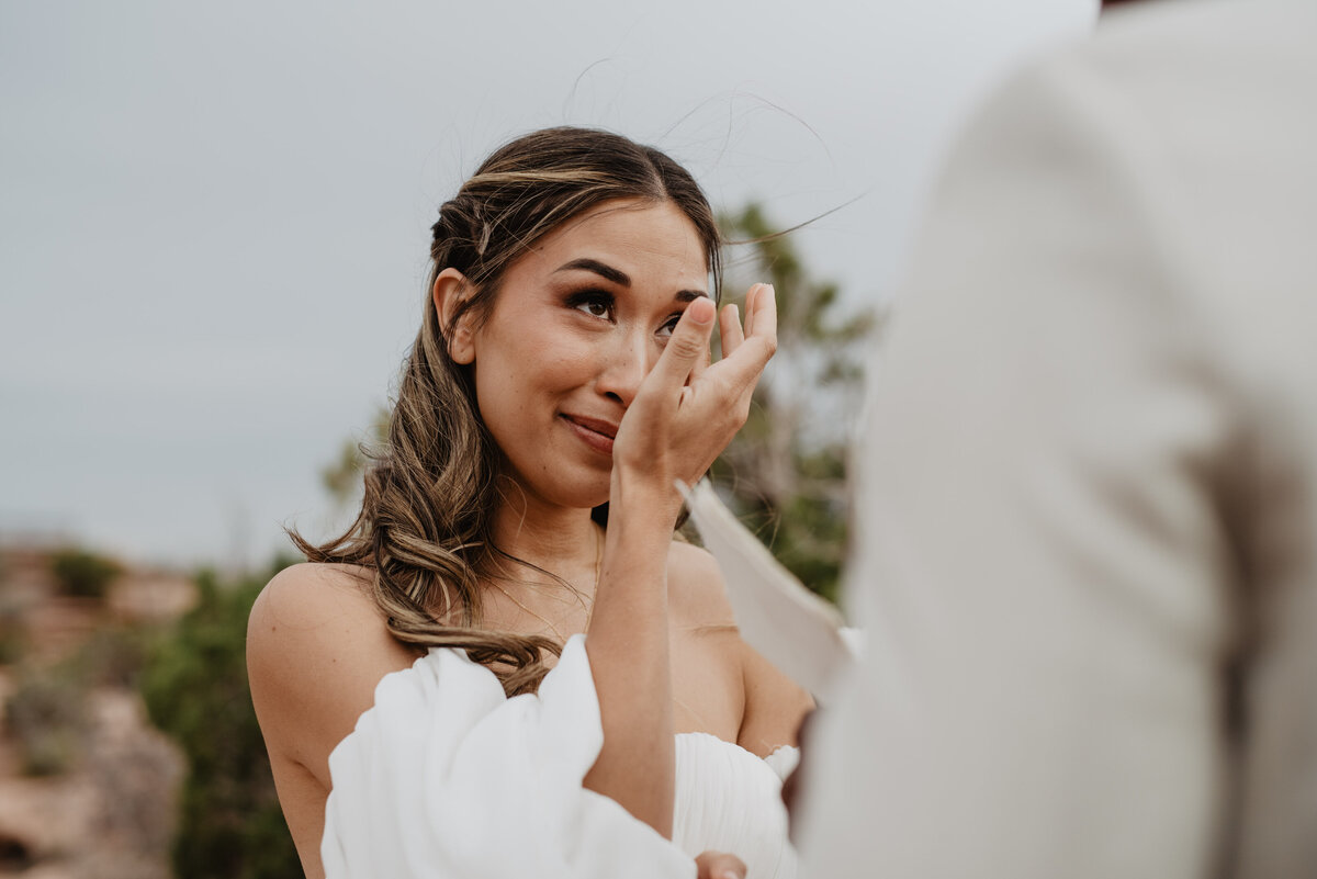 Utah elopement photographer captures bride wiping tears from face