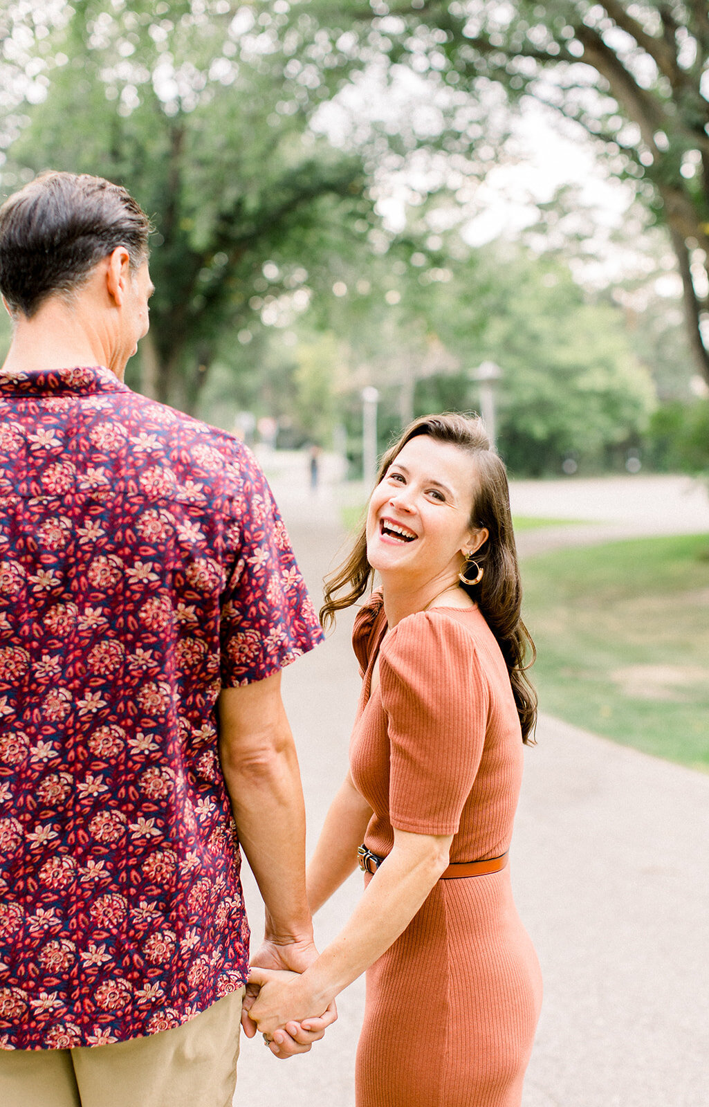 Couple holding hands as woman smiles and laughs 
