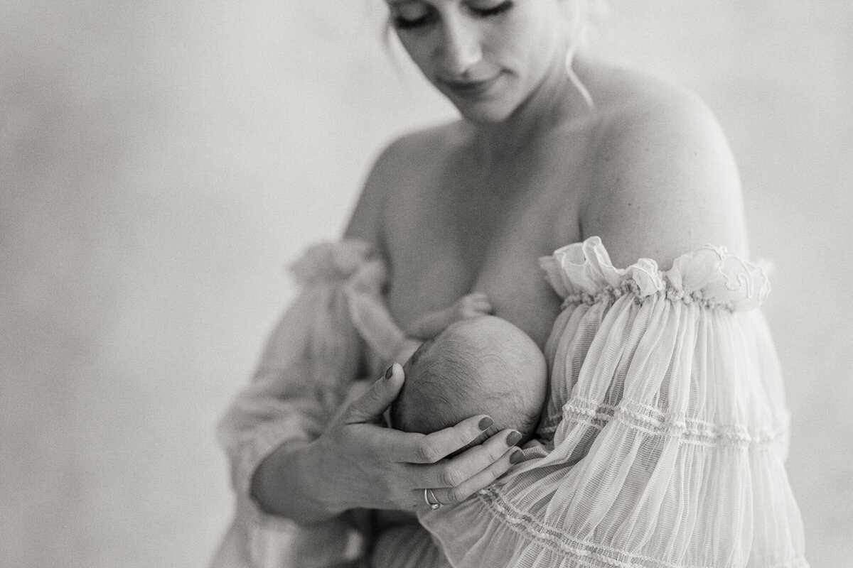 Intimate studio shot of mother holding her newborn close, showcasing their bond, taken by Bay Area Newborn Photographer, Laurel Smith.