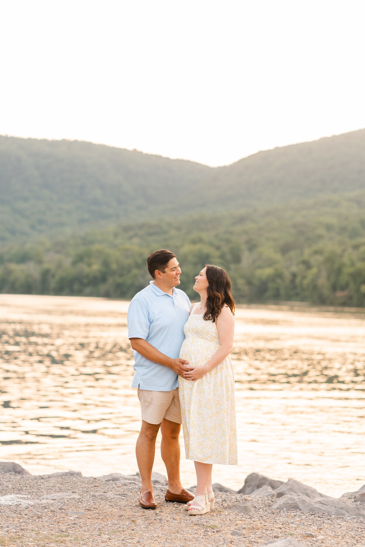 Couple hugs while standing by Tennessee River at Sunset