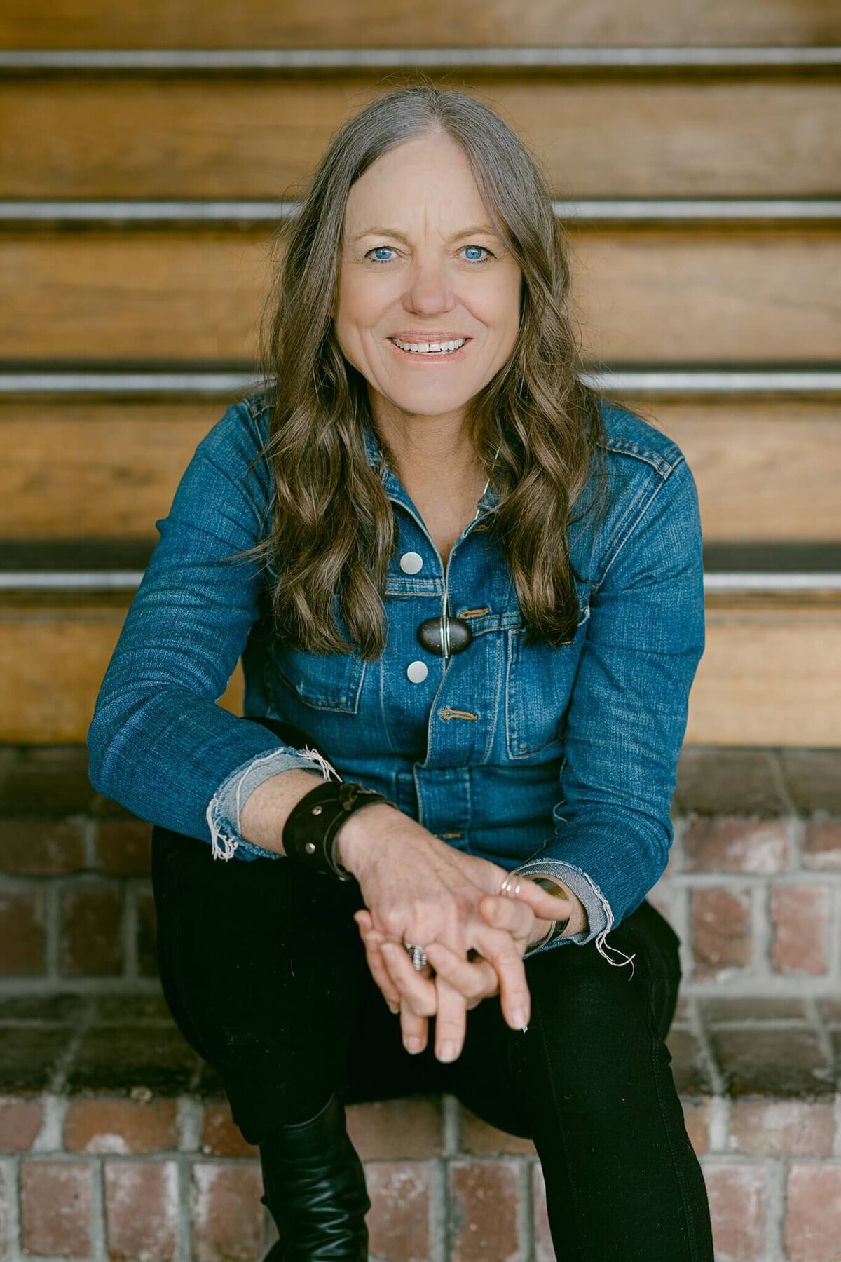 book author headshot sitting in steps in truckee wearing jean jacket