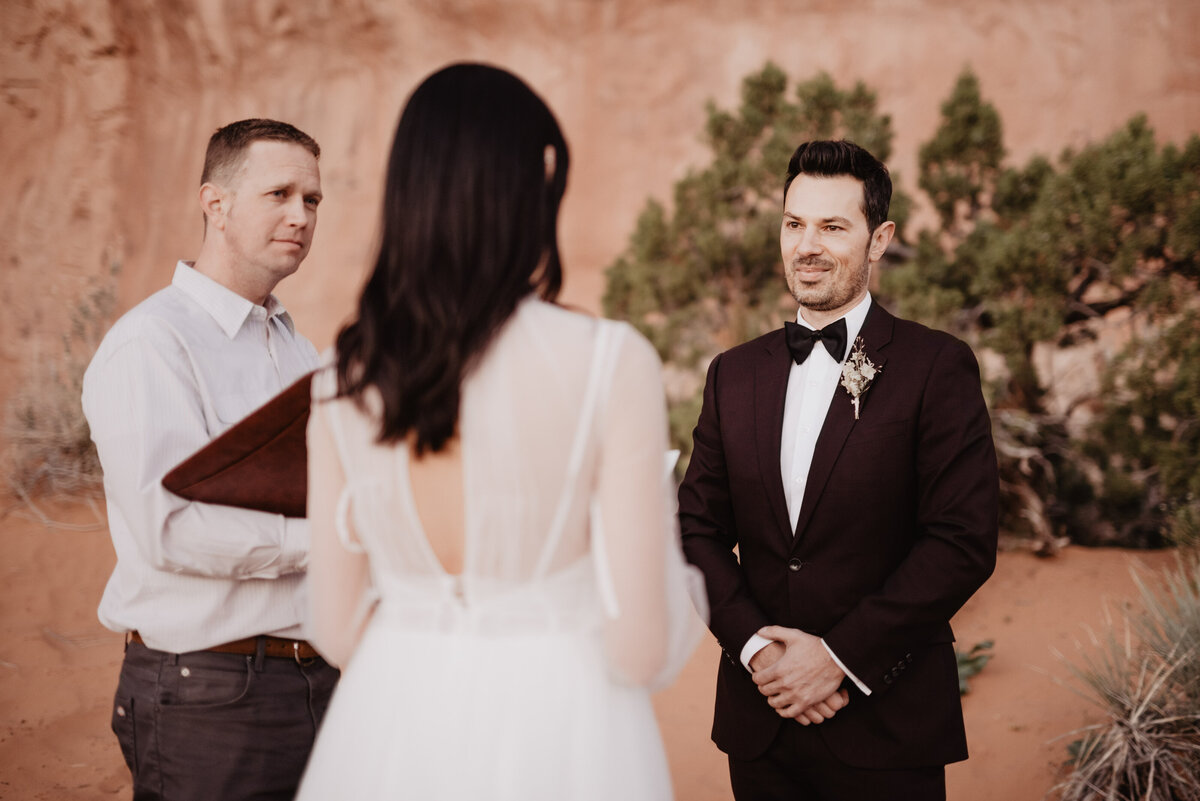 Utah elopement photographer captures groom looking at bride during intimate wedding ceremony