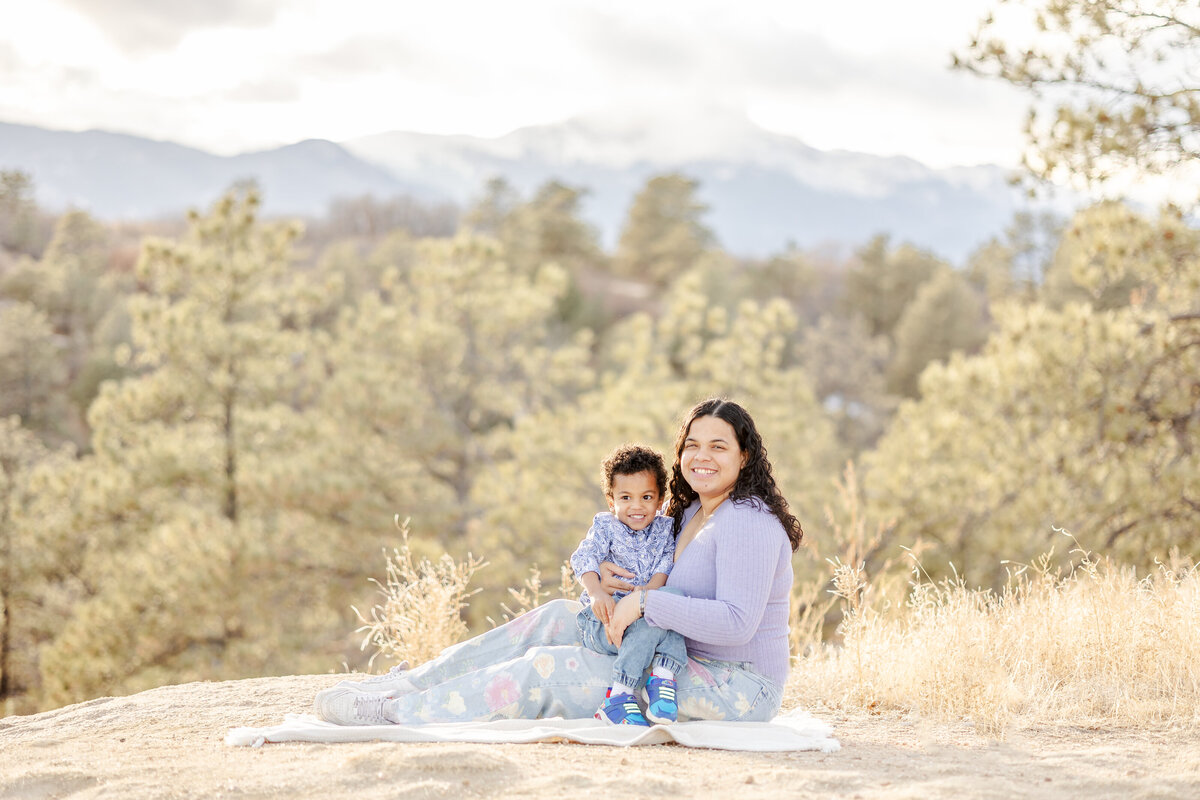 Colorado Springs Family Photographer - Mom and Son sitting in front of mountains and trees