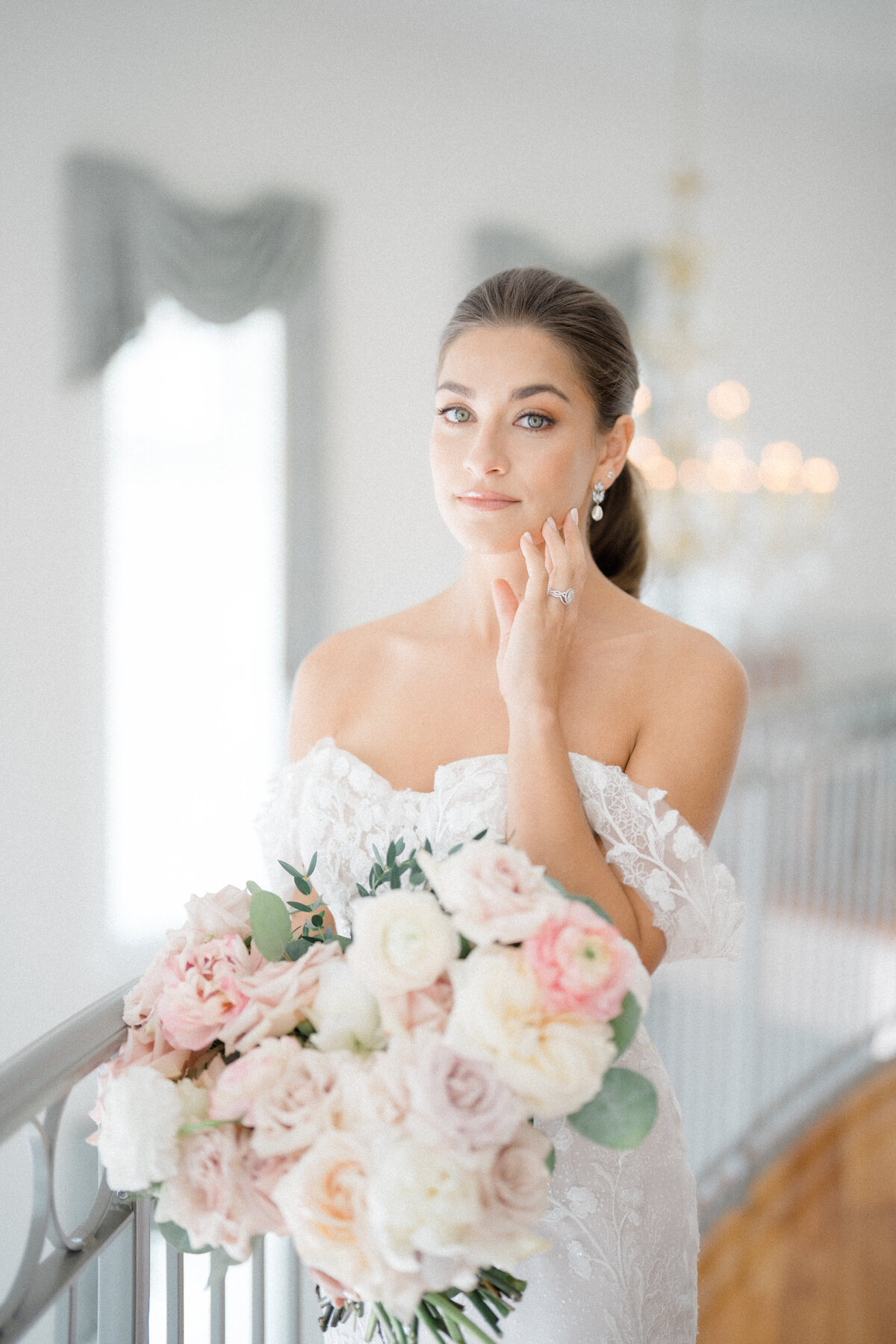 Bride holding a romantic bouquet with blush and white florals, including roses and peonies, designed by In Full Bloom Event Planning & Design.