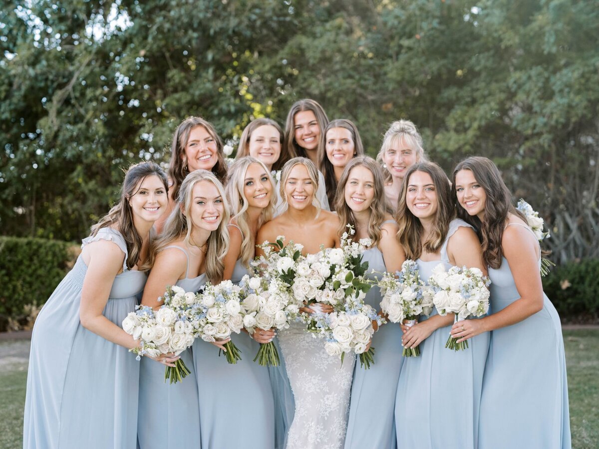 This group of gals all hold flower arrangements by Primrose and Petals.