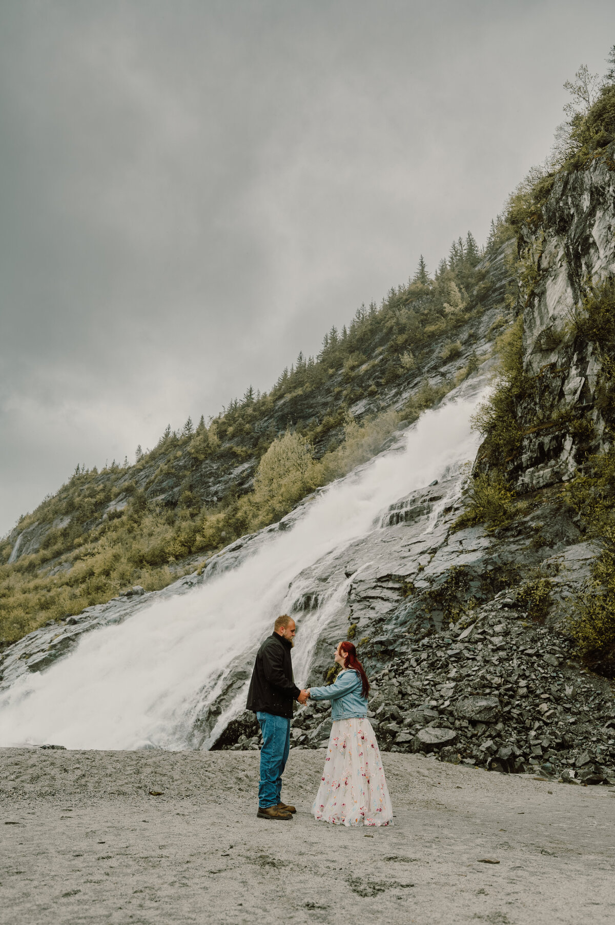 couple stand by the waterfall and speaking