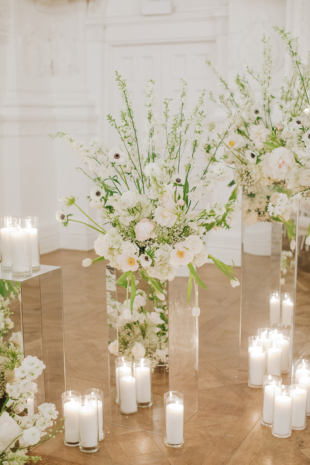 Arrangements of lush white flowers and airy greenery decorate a wedding ceremony at Maison Principale.