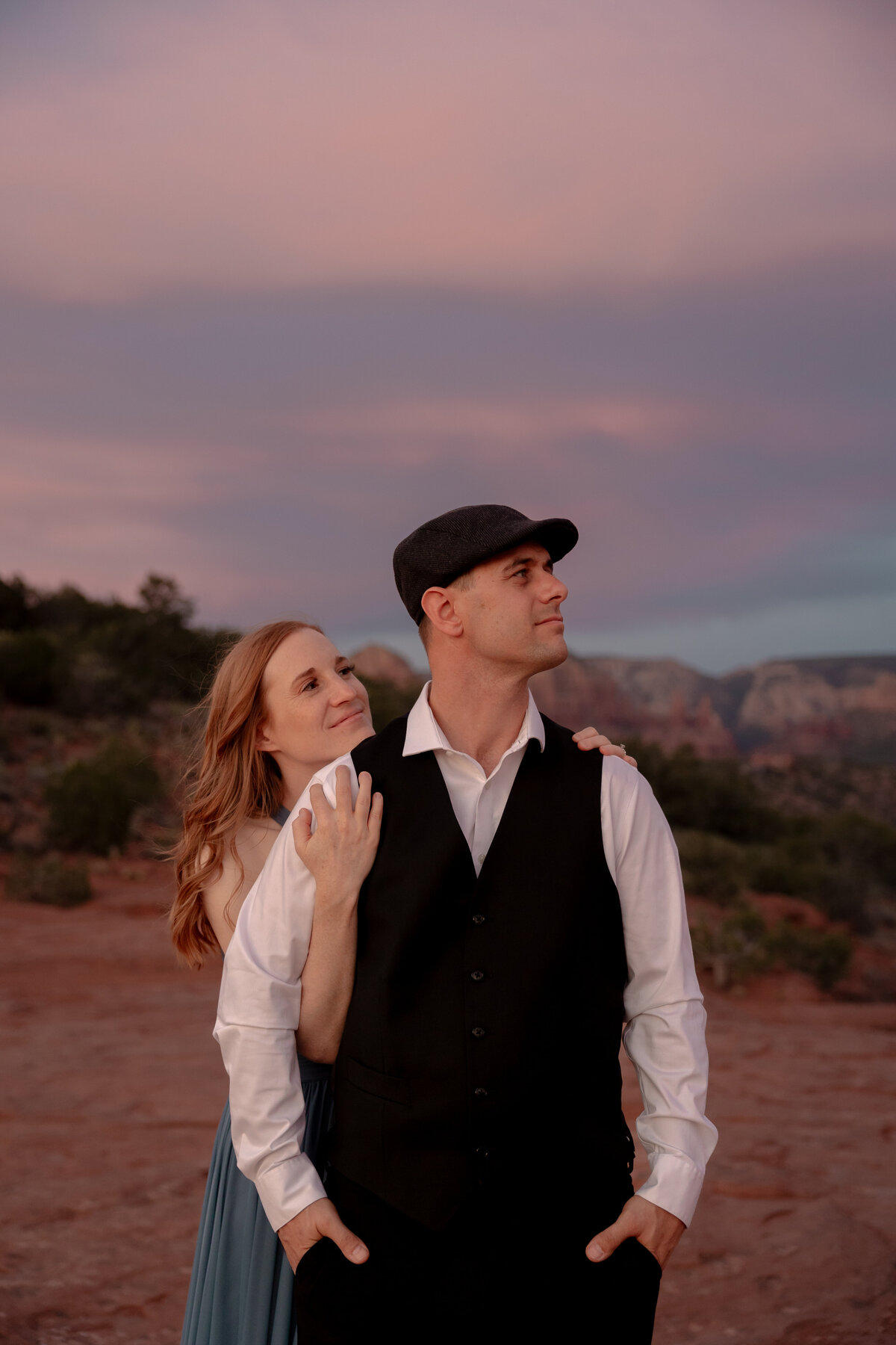 Couple standing against red rock backdrop during Sedona engagement session