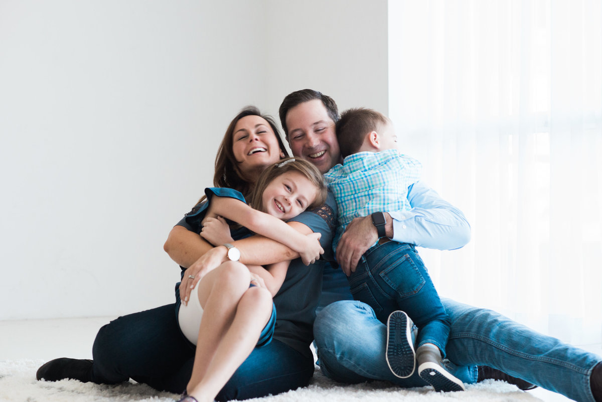 family of four laughing during photography session