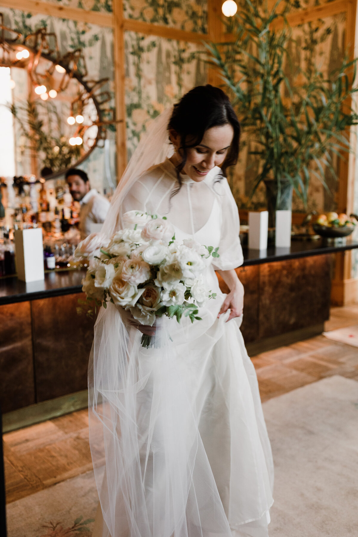 Bride carrying bouquet of white florals for intimate wedding in Austin