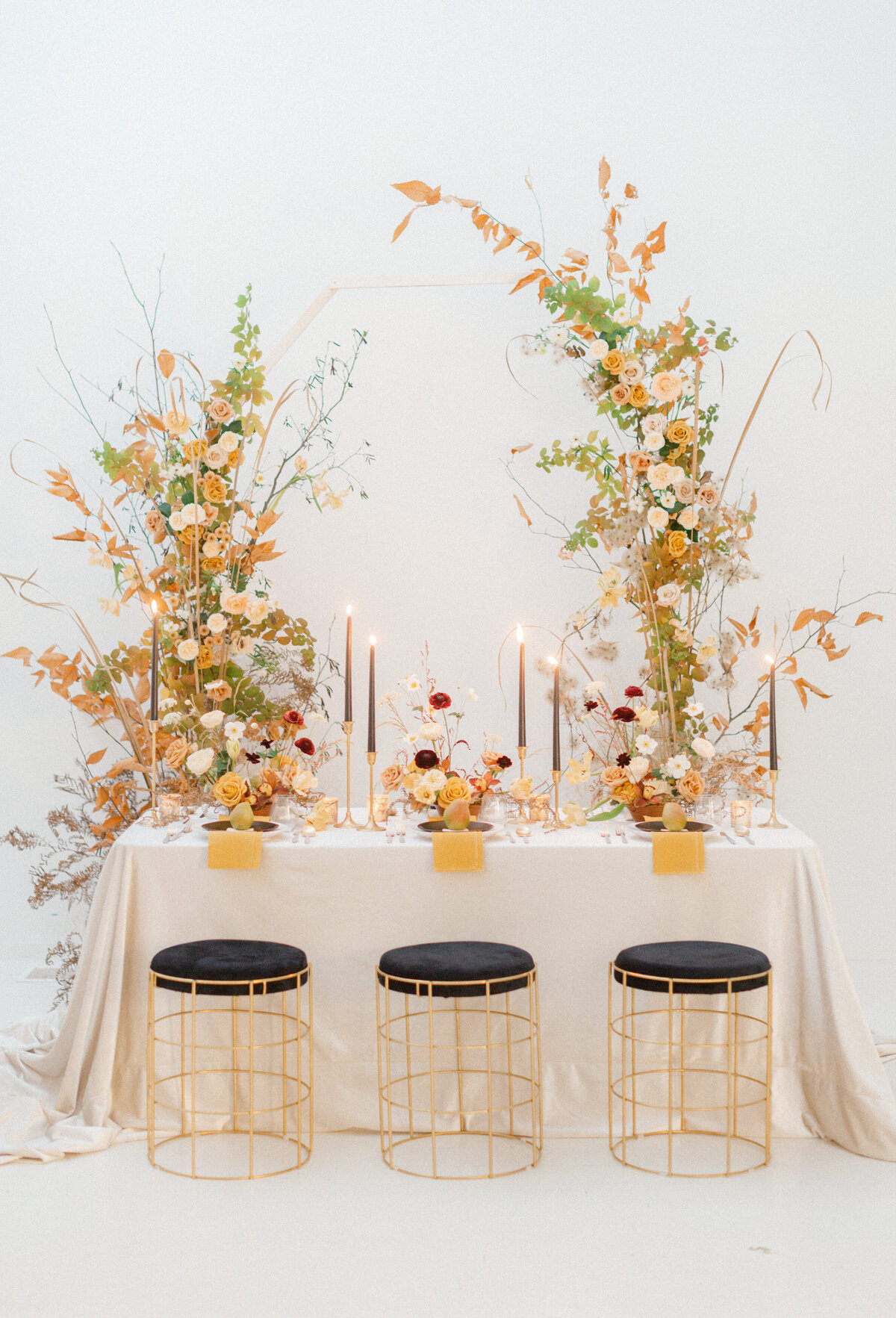 A sweetheart table at a Montreal wedding is framed by pillars of organic autumn flowers.