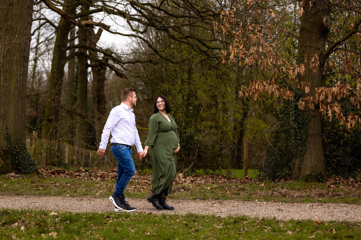 zwangere vrouw en partner lopend in herfst