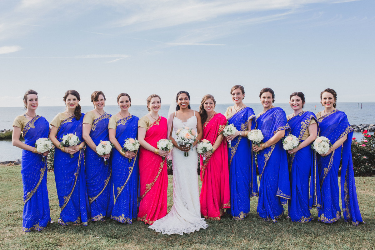 Bridesmaids  pose in sarees with the bride at The Oyster Farm