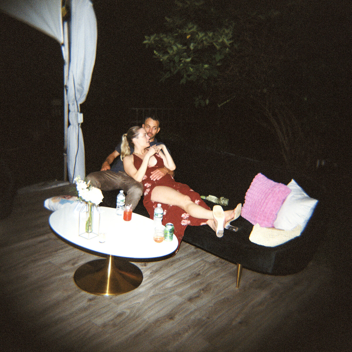 Photo of couple on couch on film in private backyard party by Mira Park Photography NY based wedding photographer