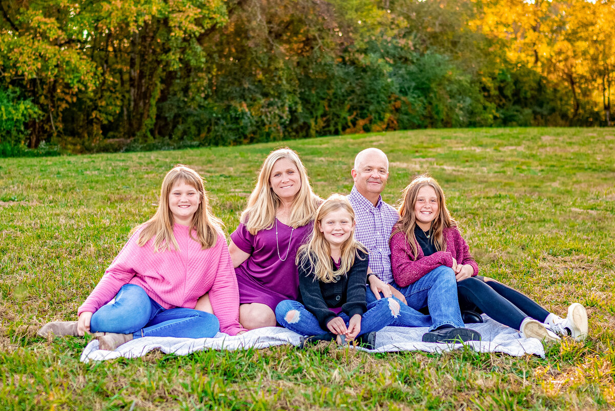 A mom and dad pose with their three daughters for family pictures  at Hayes Nature Preserve in Owens Cross Roads