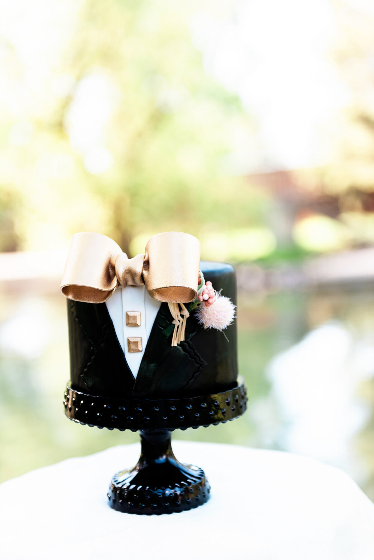 Fun and trendy tuxedo groom's wedding cake, with gold details, created by Black Dog Bakery, creative & eclectic cakes & desserts in Calgary, Alberta, featured on the Brontë Bride Vendor Guide.