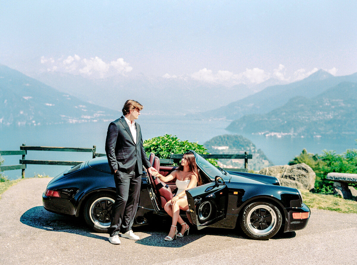 Couple with black convertible Porsche for their Italy engagement session, photographed by Italy wedding photographer.