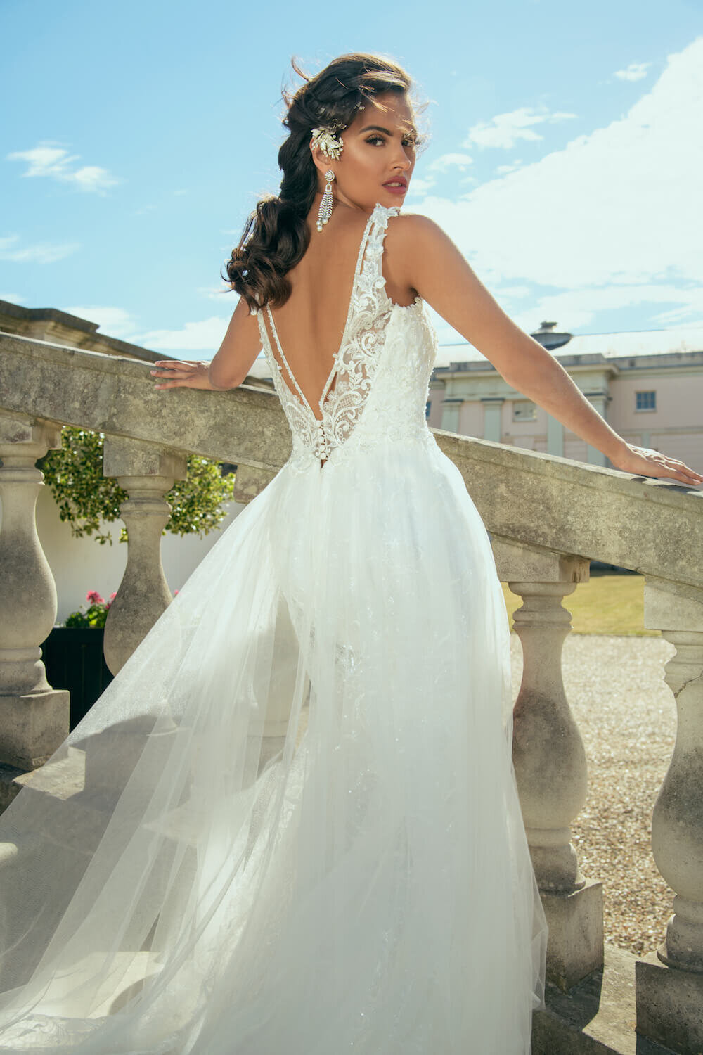 Beautiful bride in a white dress posing on a stone wall