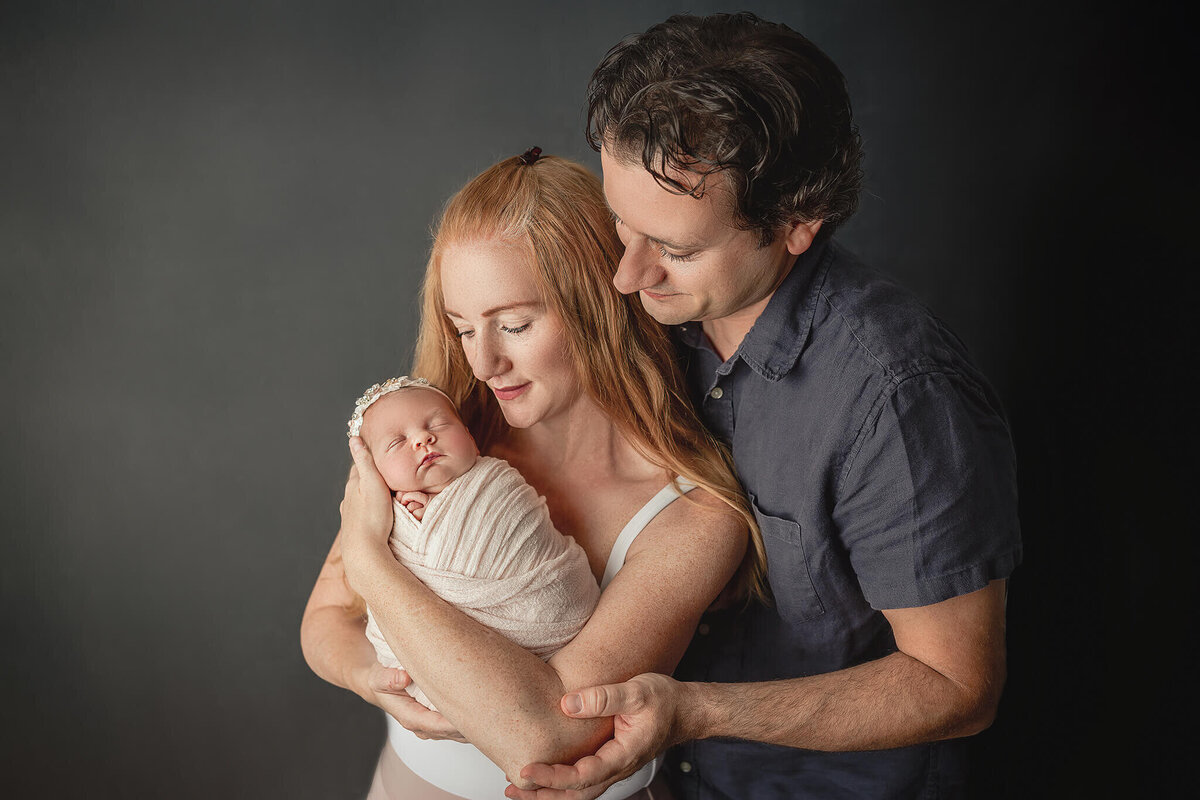new parents snuggle in close for newborn potraits at Hamilton, On studio