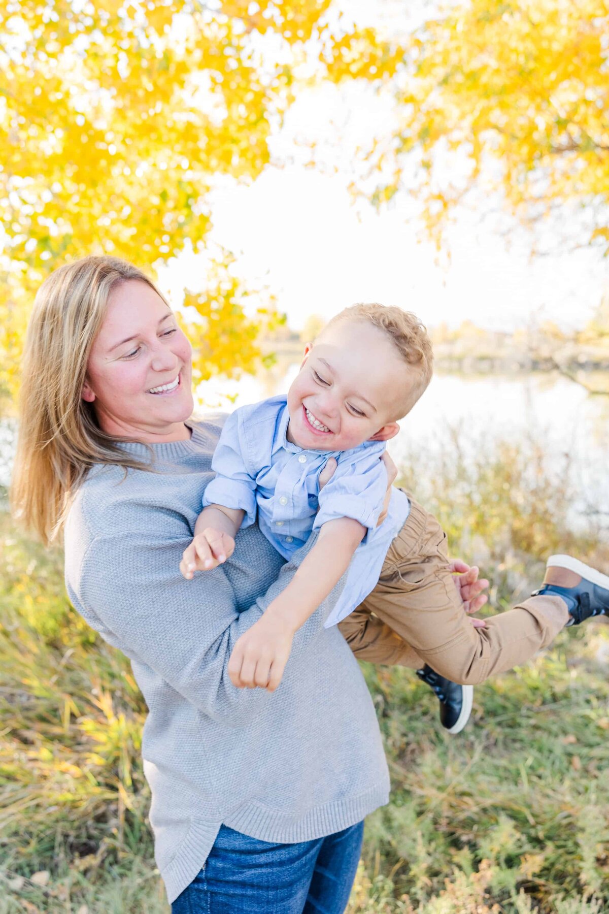 Mom tickles son during fall photos at Golden Ponds, CO