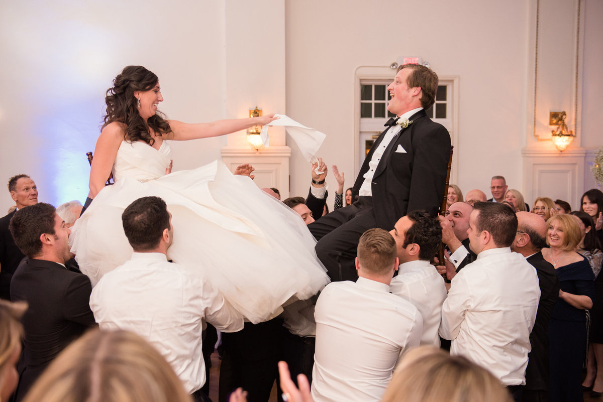Bride and groom on chair at The Bourne Mansion
