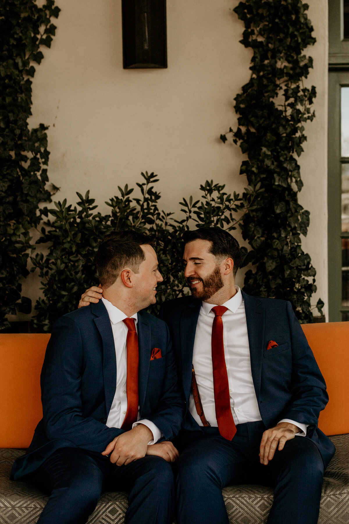 two grooms sitting on a couch together before their ceremony