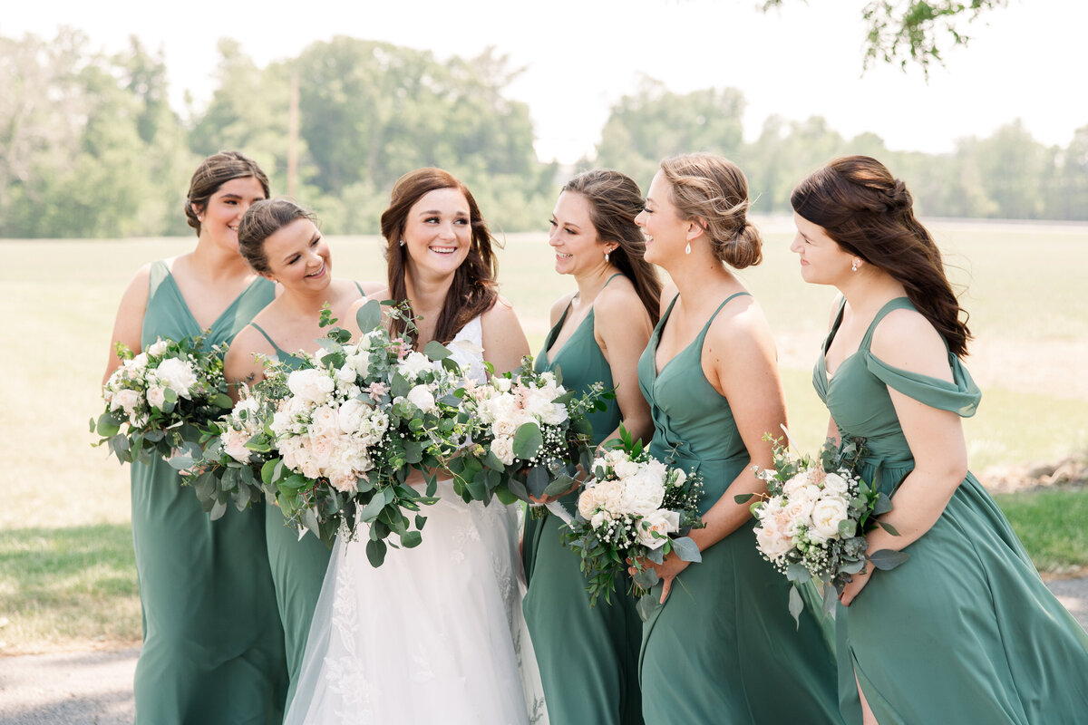 Bride & Bridesmaids smiling at each other sunny day at Arlington Acres OH