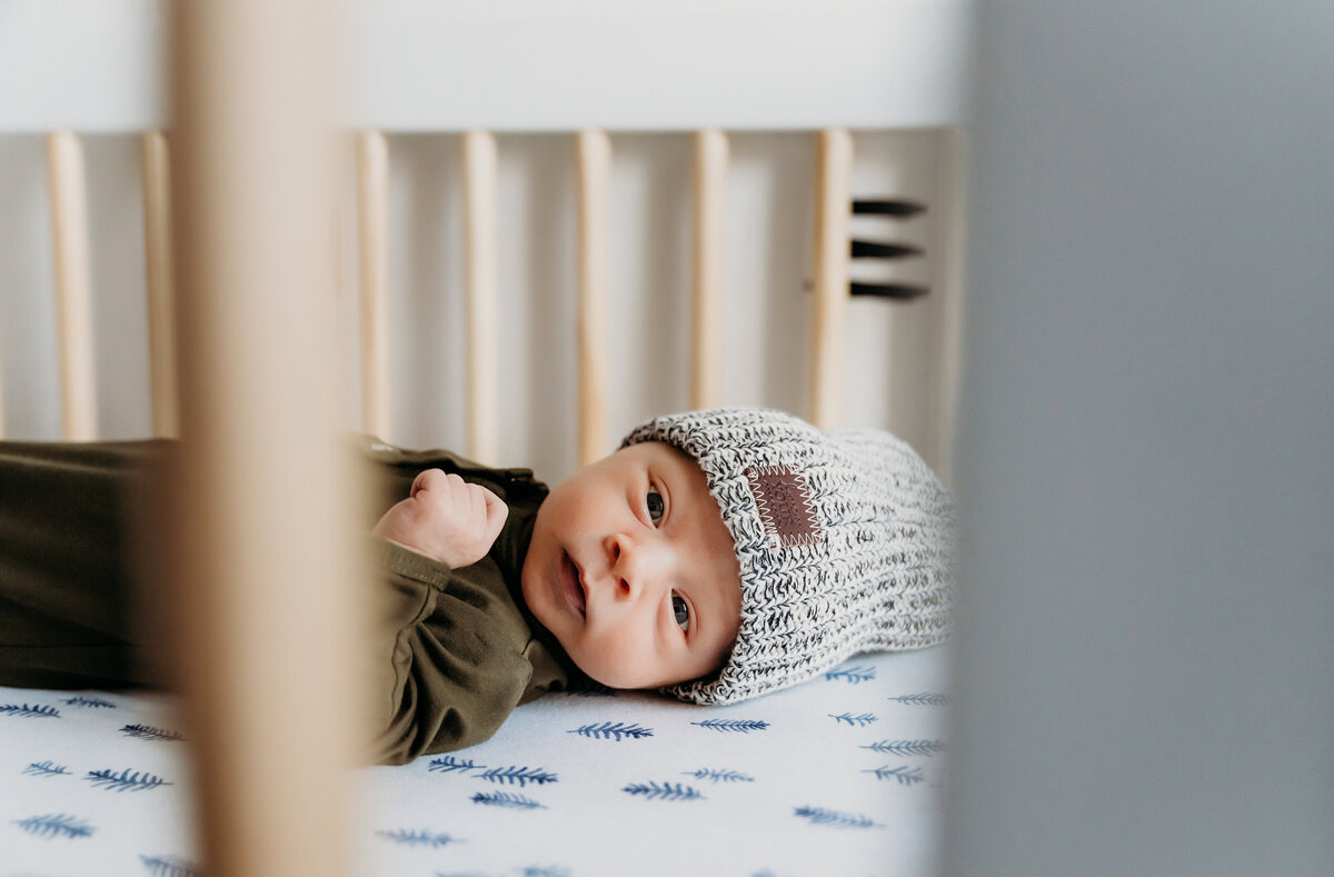 Newborn Photographer,  a baby boy lays in his crib