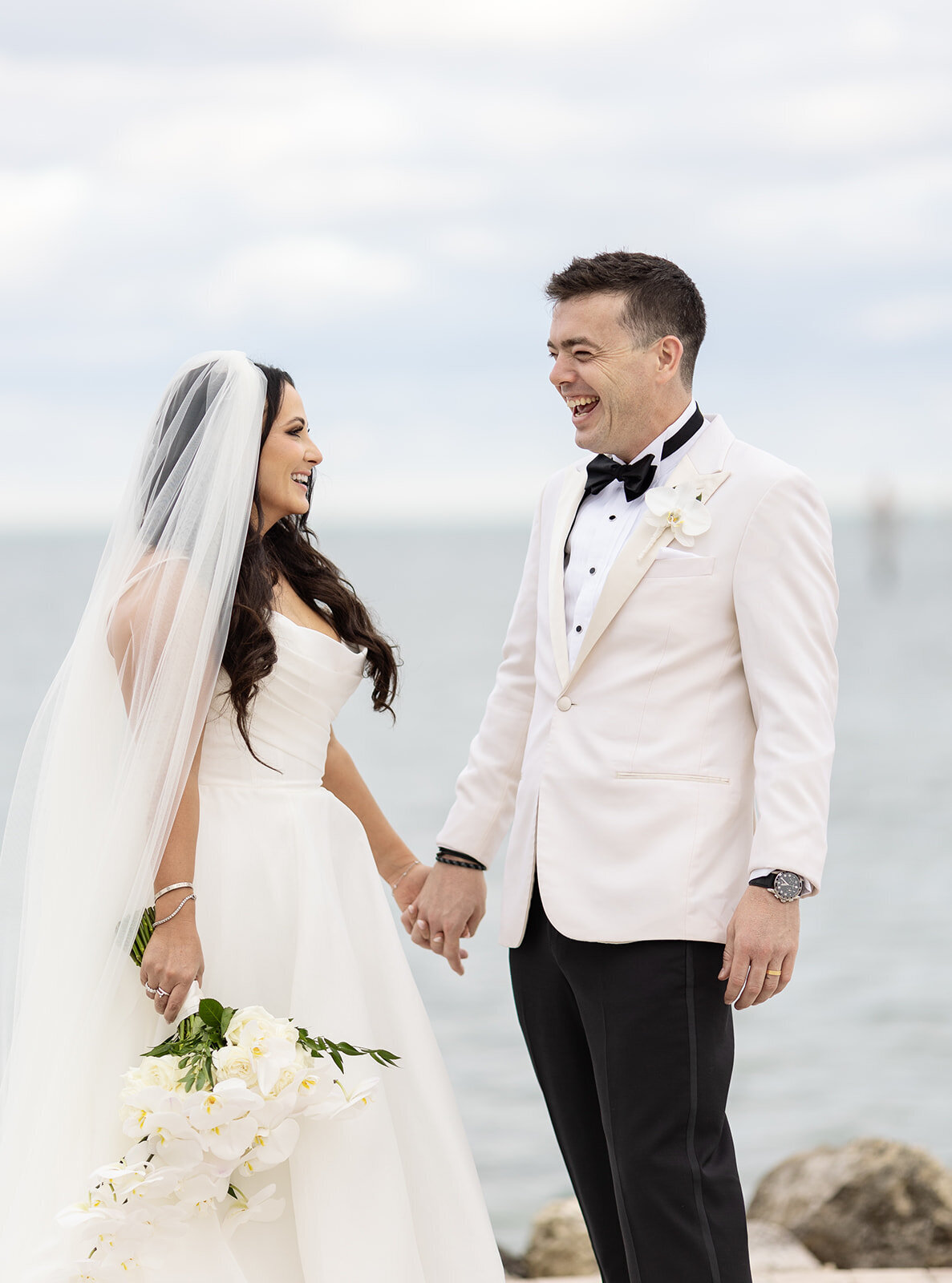 The bride and groom laughing joyfully during their intimate wedding shoot at Ocean Reef in Key Largo, captured by Claudia Amalia Photography.