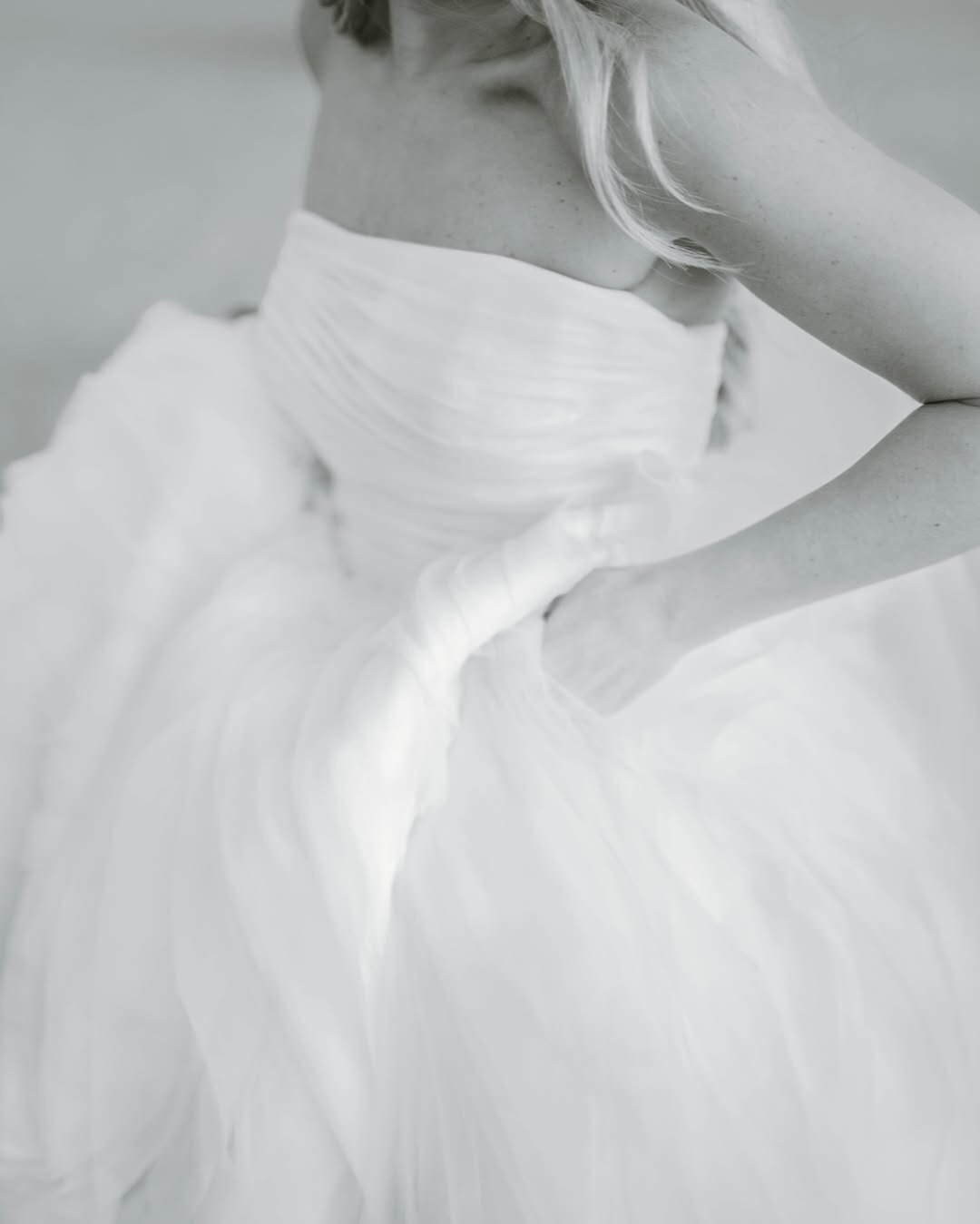 Wedding Photographer RI | Close-up of a woman in a flowing white wedding dress, hand resting on her waist.