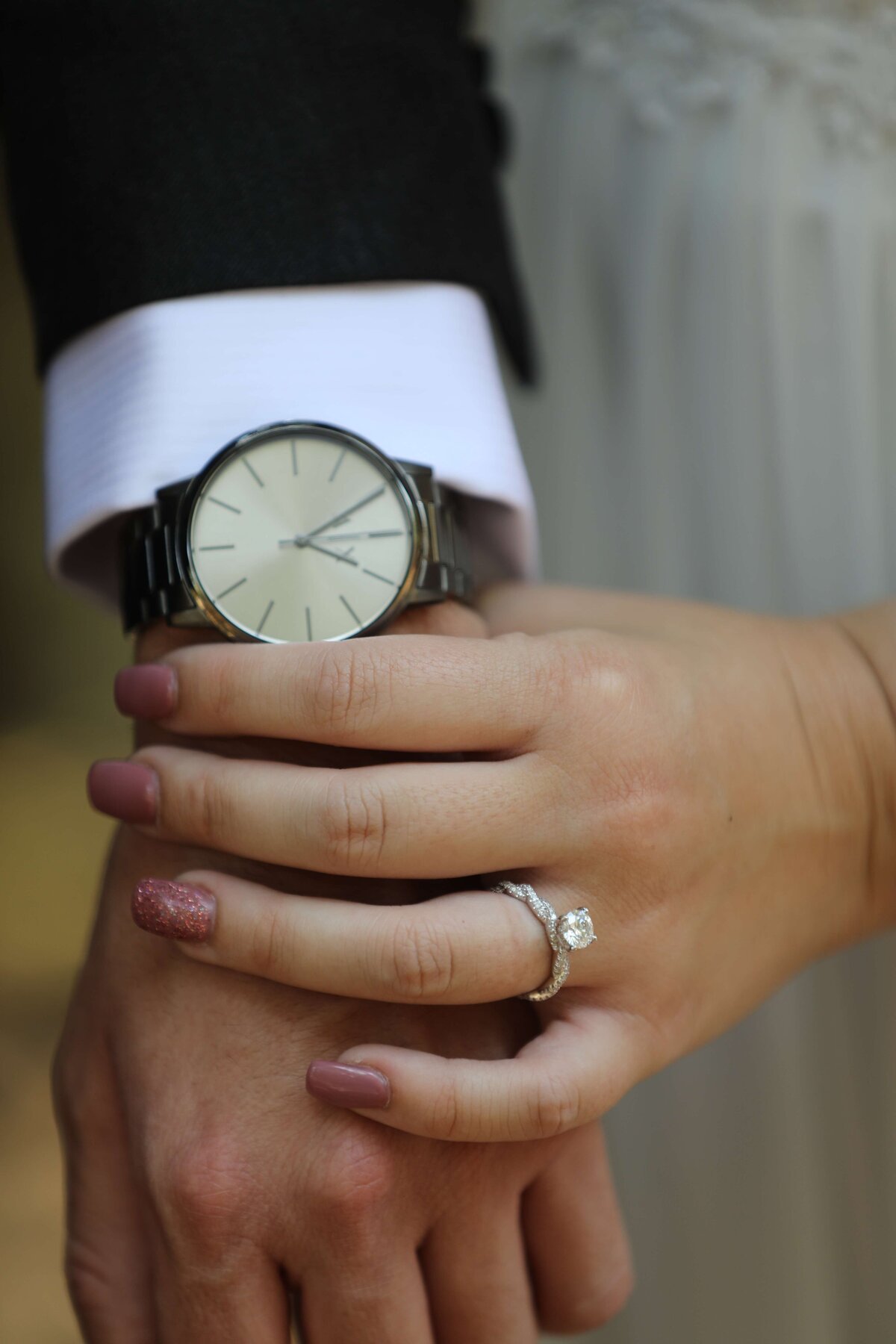 Newport Beach Wedding photographer bride holding groom's hand and showing off his watch and her wedding ring