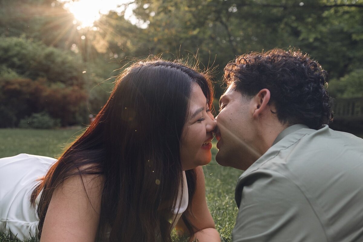 Romantic close-up of couple nose-to-nose with golden sunlight behind them.
