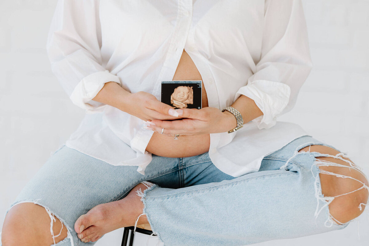 maternity portrait of mom holding sonogram picture in front of belly Longview, Texas